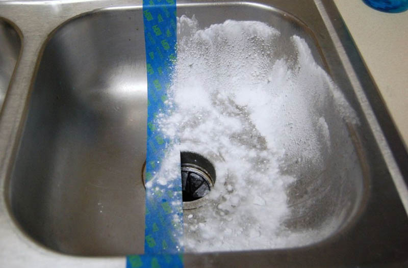 Làm ướt bề mặt của chậu rửa chén bằng nước, rồi rắc bột banking soda lên bề mặt