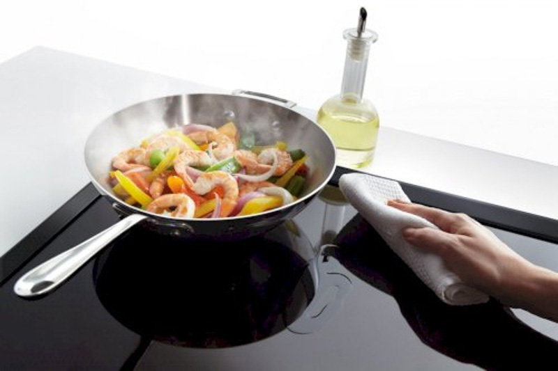 Dùng khăn sạch thấm nước cơm sôi để tẩy đi các vết dầu mỡ trên bề mặt bếp