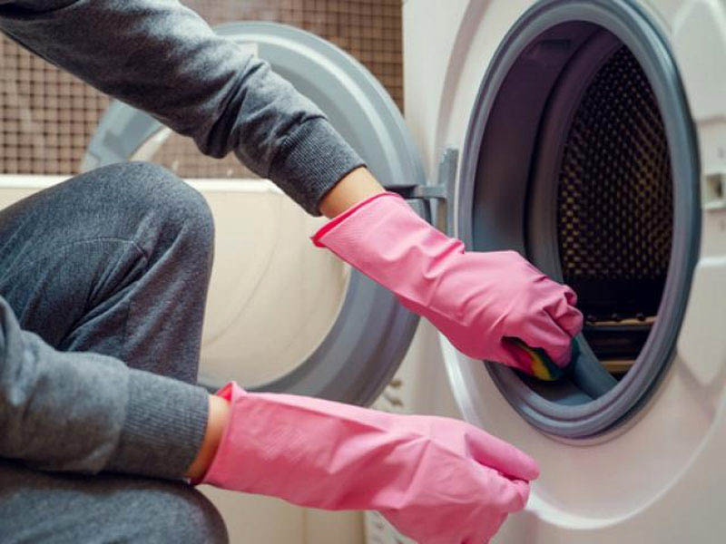 Sử dụng chiếc khăn sạch hoặc miếng bọt biển đã thấm dung dịch tẩy rửa để chà bề mặt trong lẫn ngoài cửa máy giặt